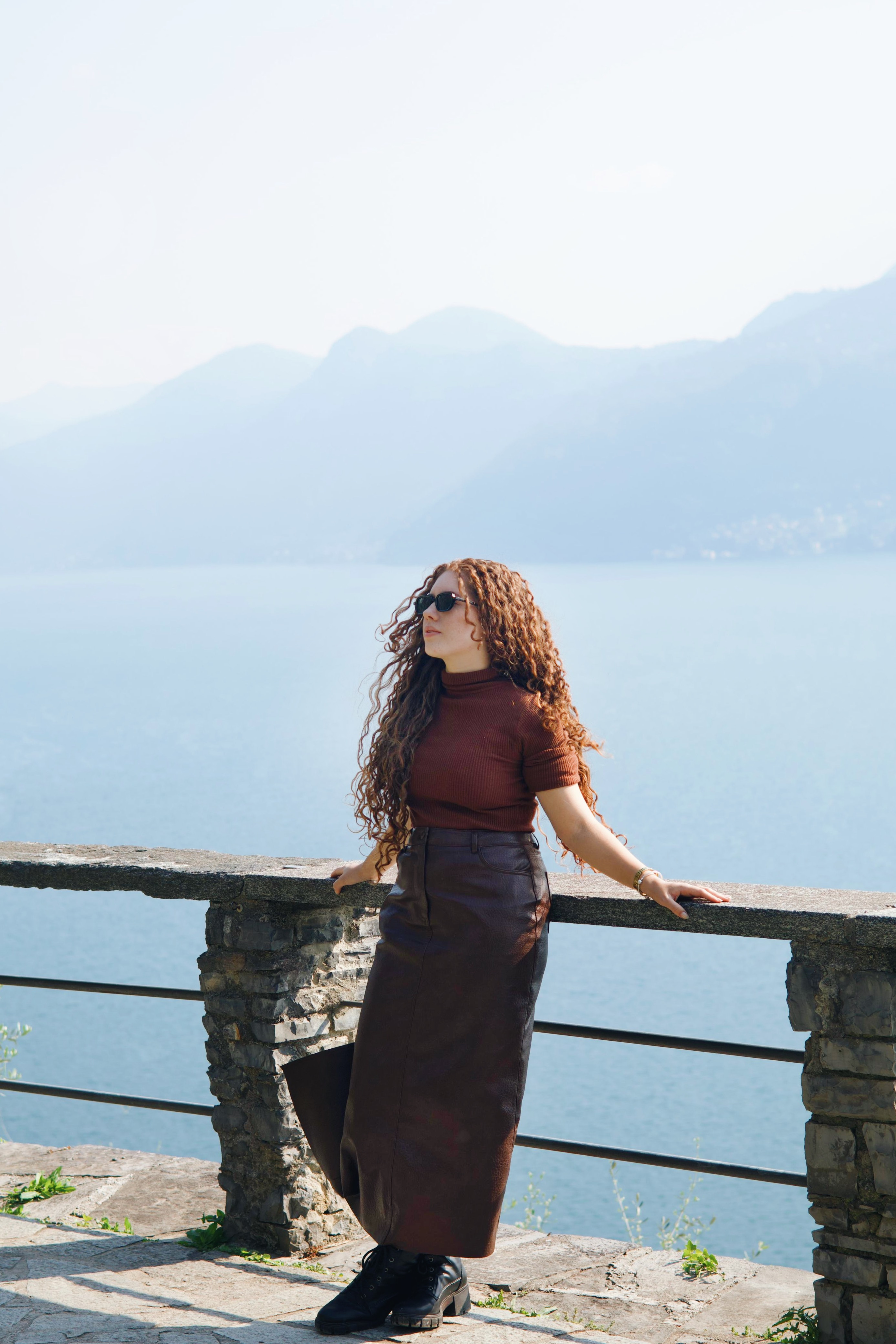 Pessoa diante do Lago di Como e das montanhas ao fundo