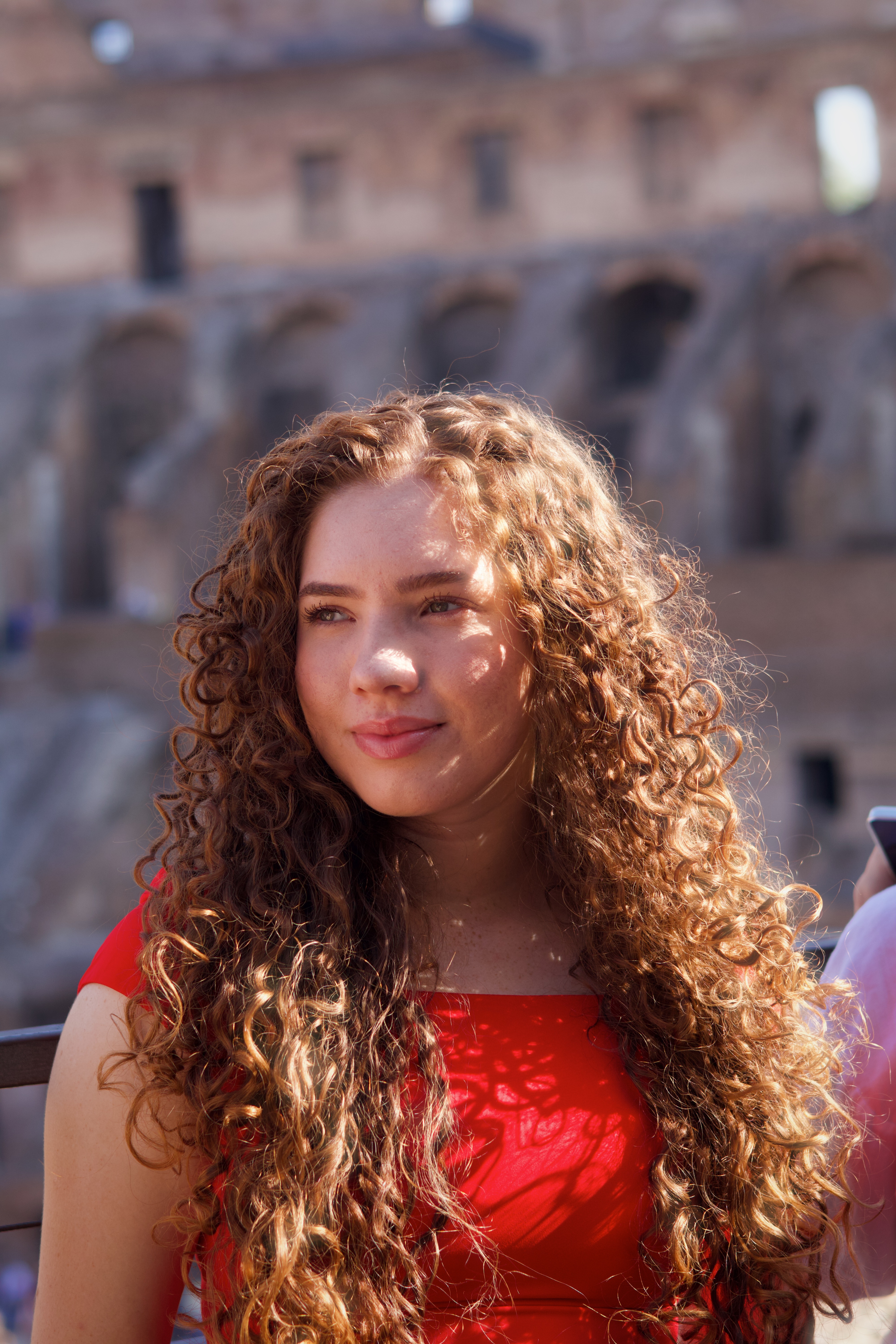 Retrato feminino diante de uma fachada histórica em Roma