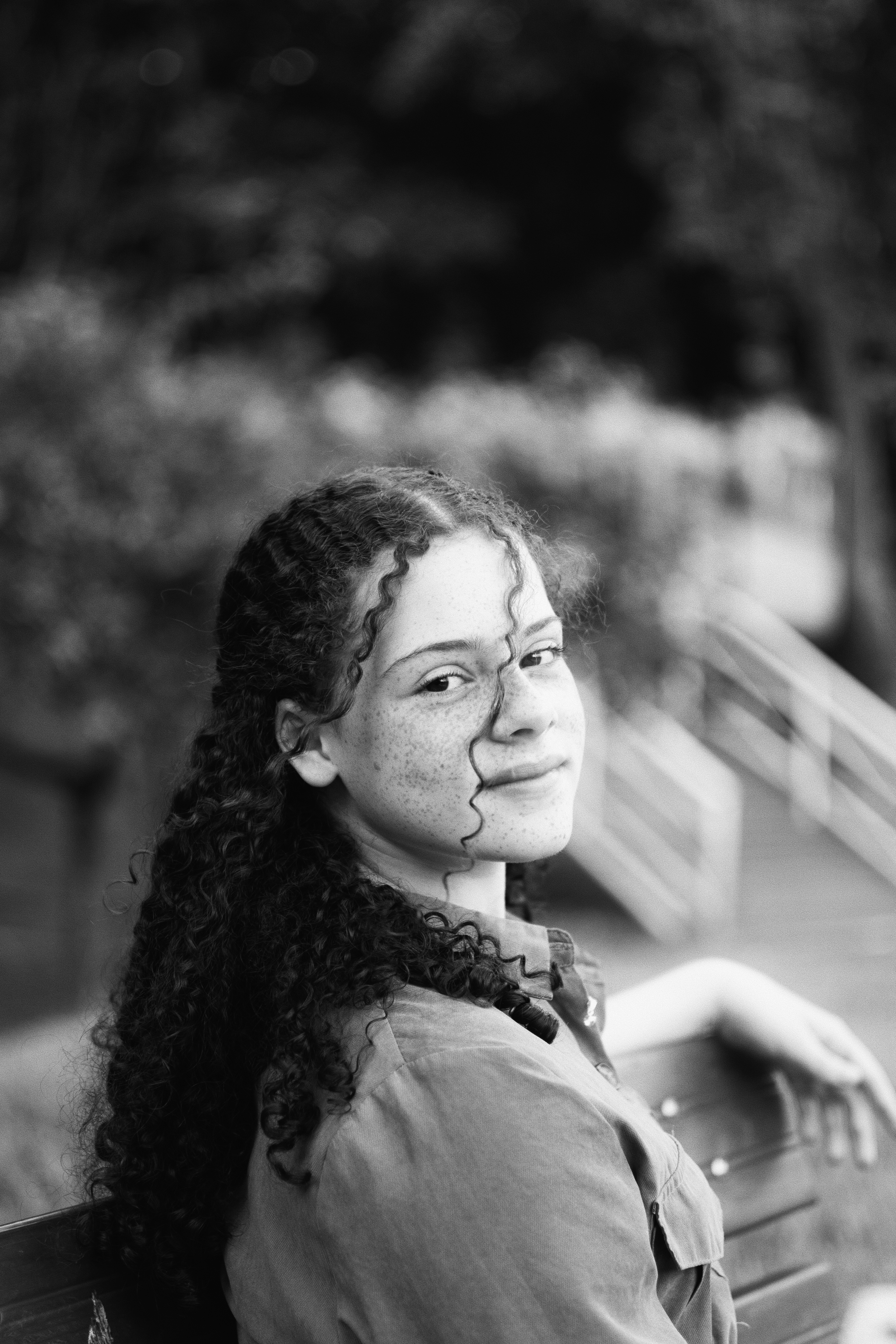 Allana em retrato preto e branco entre folhagens